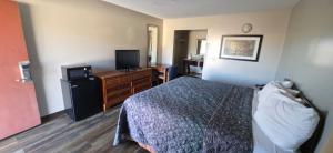 a hotel room with a bed and a television at Budget Inn in Dothan