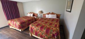 a hotel room with two beds and a window at Budget Inn in Dothan