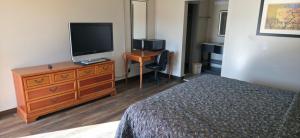a bedroom with a bed and a television on a dresser at Budget Inn in Dothan +29 photos