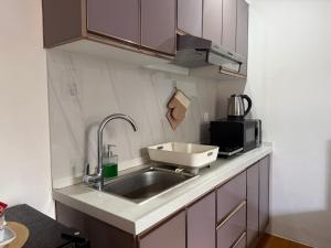 a kitchen with a sink and a microwave at EA Staycation in Baguio