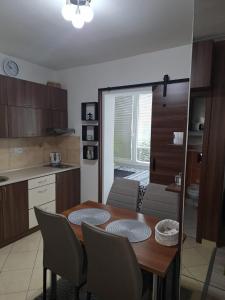 a kitchen with a table and chairs in a kitchen at Apartmán Mery in Podhájska