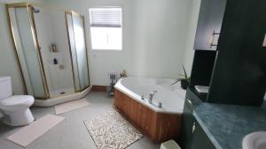 a bathroom with a tub and a shower and a toilet at Finca Saddiki in Namur +8 photos