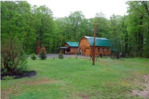 a log cabin with a green roof in a yard at Finca Saddiki in Namur