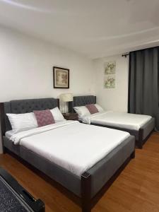 two beds sitting in a room with at EA Staycation in Baguio