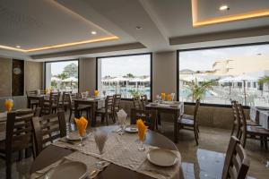 a restaurant with tables and chairs and large windows at Dar Khayam in Hammamet