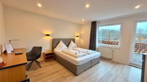 a hotel room with a bed and a desk and a window at Bootshaus Hamm in Hamm