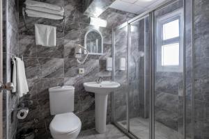 a bathroom with a toilet and a shower and a sink at The Gap Hotel Kuşadası in Kuşadası