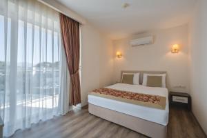 a bedroom with a large bed and a large window at The Gap Hotel Kuşadası in Kuşadası