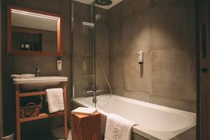 a bathroom with a bath tub and a sink at Lodji Hotel & spa in Saint-Martin-de-Belleville