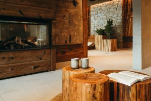 a living room with a fireplace and wooden logs at Lodji Hotel & spa in Saint-Martin-de-Belleville