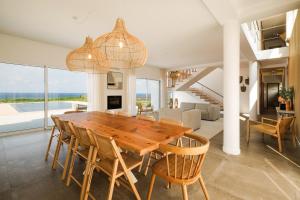 a dining room with a wooden table and chairs at Casa do Mar - North Coast Ocean Views in Calhetas