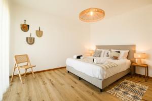 a bedroom with a bed and a chair at Casa do Mar - North Coast Ocean Views in Calhetas +60 photos