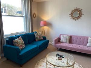 a living room with a blue couch and a glass table at No 3, apartment in the heart of Bridport, Dorset in Bridport