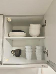a cupboard with plates and bowls on it at イマココホテル in Yogi +9 photos