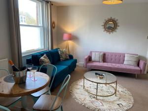 a living room with a couch and a table at No 3, apartment in the heart of Bridport, Dorset in Bridport +36 photos