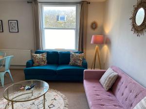a living room with a blue couch and a glass table at No 3, apartment in the heart of Bridport, Dorset in Bridport