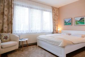a bedroom with a bed and a chair and a window at Guest House Visoko in Visoko