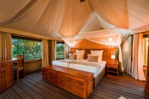 a bedroom with a bed in a tent at Mutsviri Game Lodge in Victoria Falls