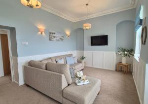 a living room with a couch and a tv at Seaview Cottage in Llanddulas