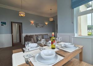a dining table with glasses and a bottle of wine at Seaview Cottage in Llanddulas