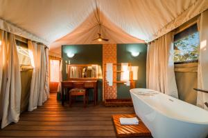 a bathroom with a tub and a sink at Mutsviri Game Lodge in Victoria Falls +70 photos