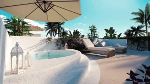 a pool with an umbrella and a couch and a chair at Luxury Resort e Hotel Ltda in Jericoacoara
