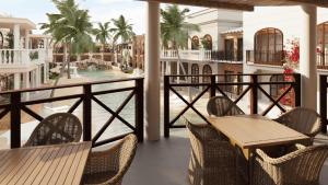 a balcony with tables and chairs and a swimming pool at Luxury Resort e Hotel Ltda in Jericoacoara