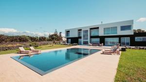 a house with a swimming pool in the yard at Casa do Mar - North Coast Ocean Views in Calhetas