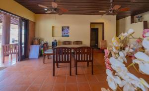 a living room with a table and chairs and a ceiling fan at Bualuang Hotel in Luang Prabang