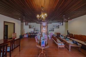 a living room with tables and chairs and a chandelier at Bualuang Hotel in Luang Prabang +40 photos