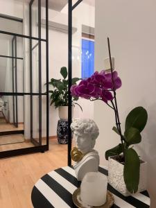 a room with a statue and a purple plant at Amadeus Studio in Baden +2 photos
