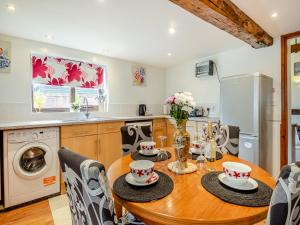 a kitchen with a wooden table and a laundry room at Pear Tree Cottage in Banham