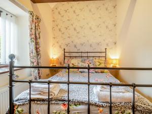 a bedroom with a metal bed in a room at Pear Tree Cottage in Banham