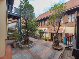 two trees in a courtyard in front of a building at Bualuang Hotel in Luang Prabang