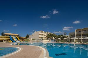 a swimming pool with a slide in front of a hotel at Dar Khayam in Hammamet