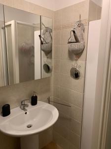 a bathroom with a sink and two baskets on the wall at Studio Seguret in Sauze d'Oulx +3 photos
