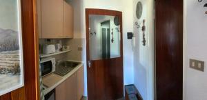 a kitchen with a door leading into a small kitchen at Studio Seguret in Sauze d'Oulx