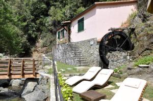 a group of white lounge chairs in front of a building at Cà du Ferrà - Farm and Relax in Bonassola