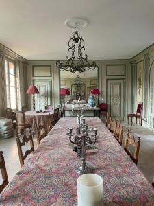 a large dining room with a long table and chairs at Domaine du Chesne in Salbris