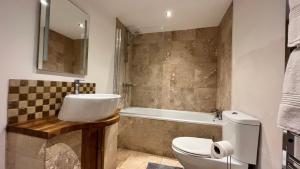 a bathroom with a sink and a toilet and a tub at Flat 1- The Marilyn in Banbury +3 photos