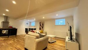 a living room with a couch and a tv at Flat 1- The Marilyn in Banbury