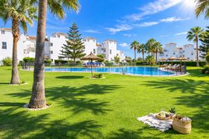 a resort yard with a swimming pool and palm trees at Noctua Duquesa Beach 009 in Manilva