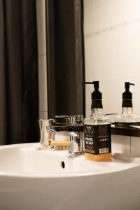 a bathroom sink with a bottle of mouthwash and a mirror at City Pension in Reichenbach im Vogtland +66 photos