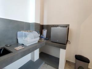 a bathroom with a sink and a microwave on a counter at Calvian Villa in Walliwala East