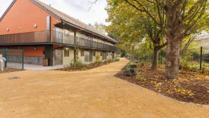 a dirt road next to a building with a tree at Campanile NATURE - Clermont-Ferrand Nord Riom in Riom