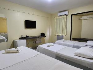 ein Hotelzimmer mit zwei Betten und einem Schreibtisch in der Unterkunft JR Hotel in João Pessoa + 53 Fotos
