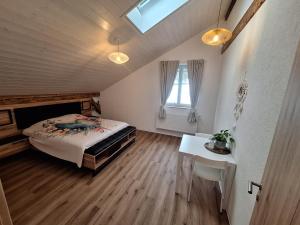 a bedroom with a bed and a table and a window at Chambres d'hôtes Les Fontaines in Tramelan