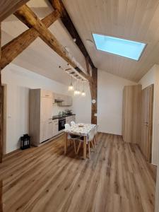a living room with a table and a kitchen at Chambres d'hôtes Les Fontaines in Tramelan