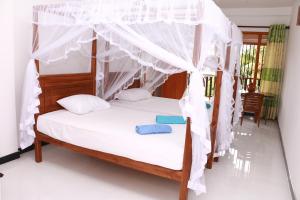 - une chambre avec un lit à baldaquin dans l'établissement Dilara Resort Mirissa, à Mirissa