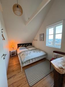 a bedroom with a bed and a window at Melar Guesthouse in Kópasker